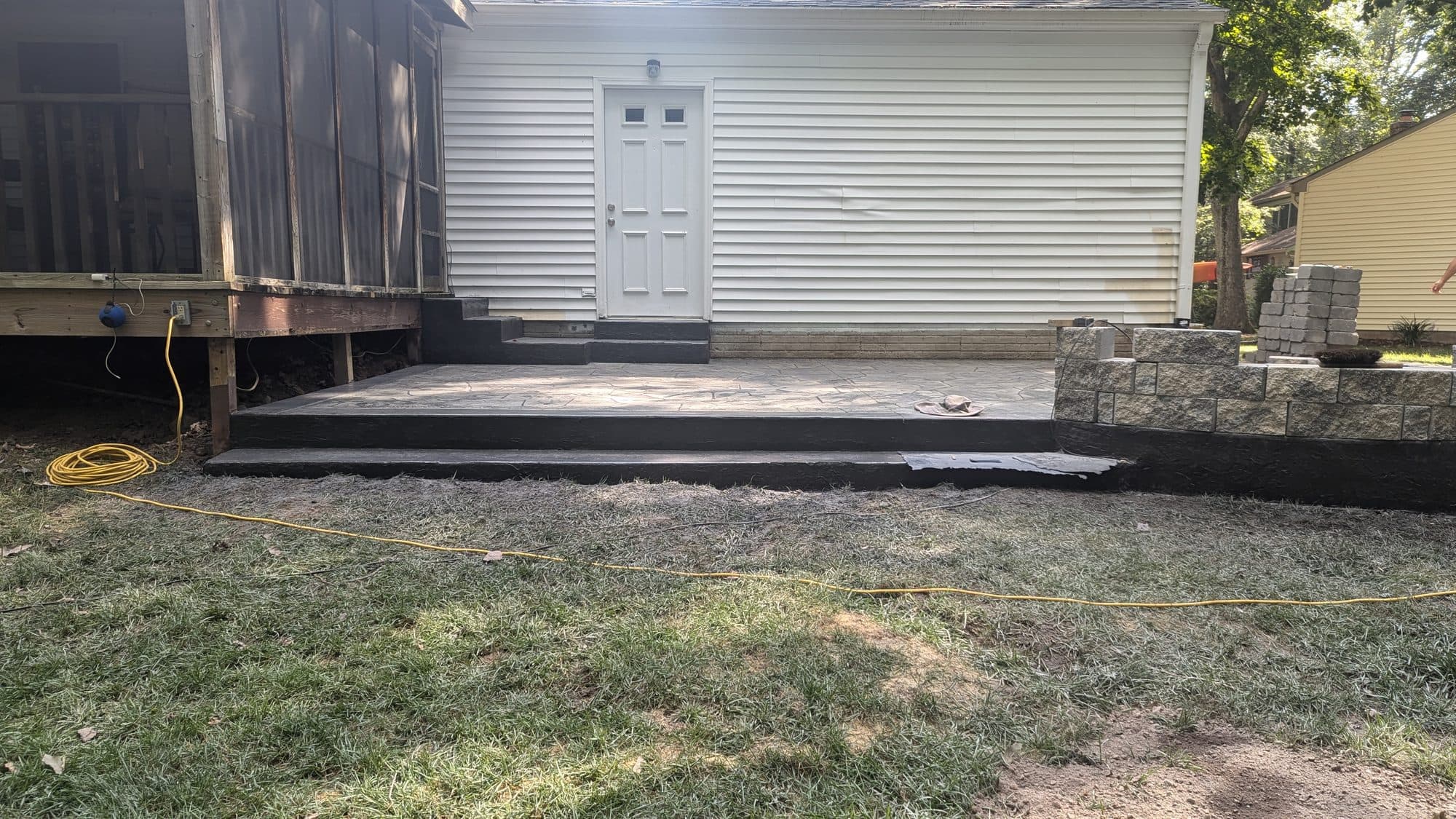 Finished stamped concrete patio with painted steps, daytime