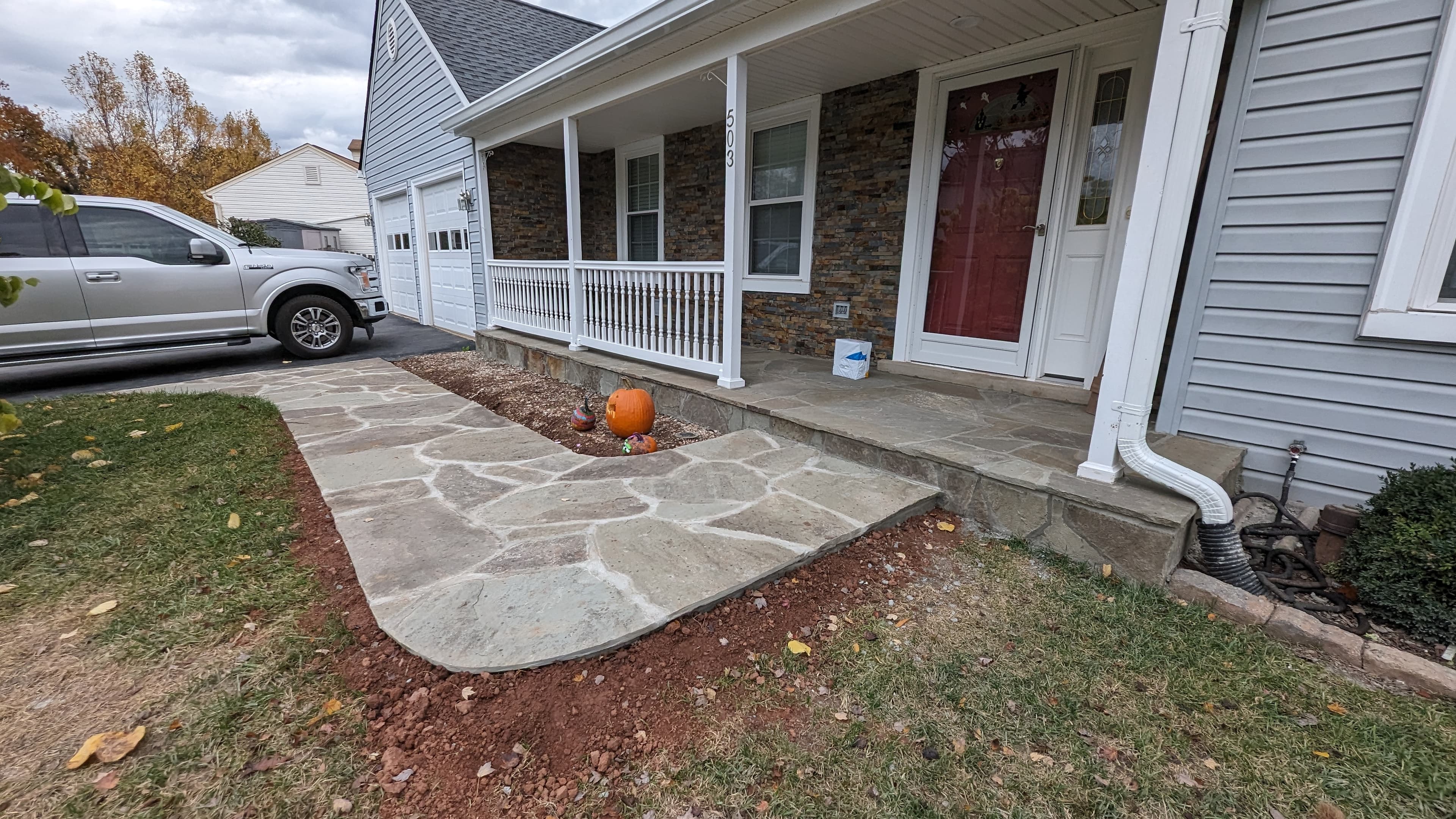 Flagstone walkway and porch landing with stacked stone veneer skirting