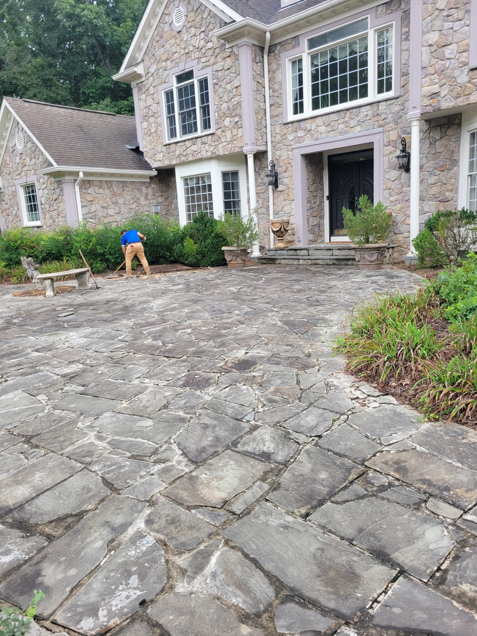 Crew tearing out the old flagstone driveway during a McLean concrete replacement
