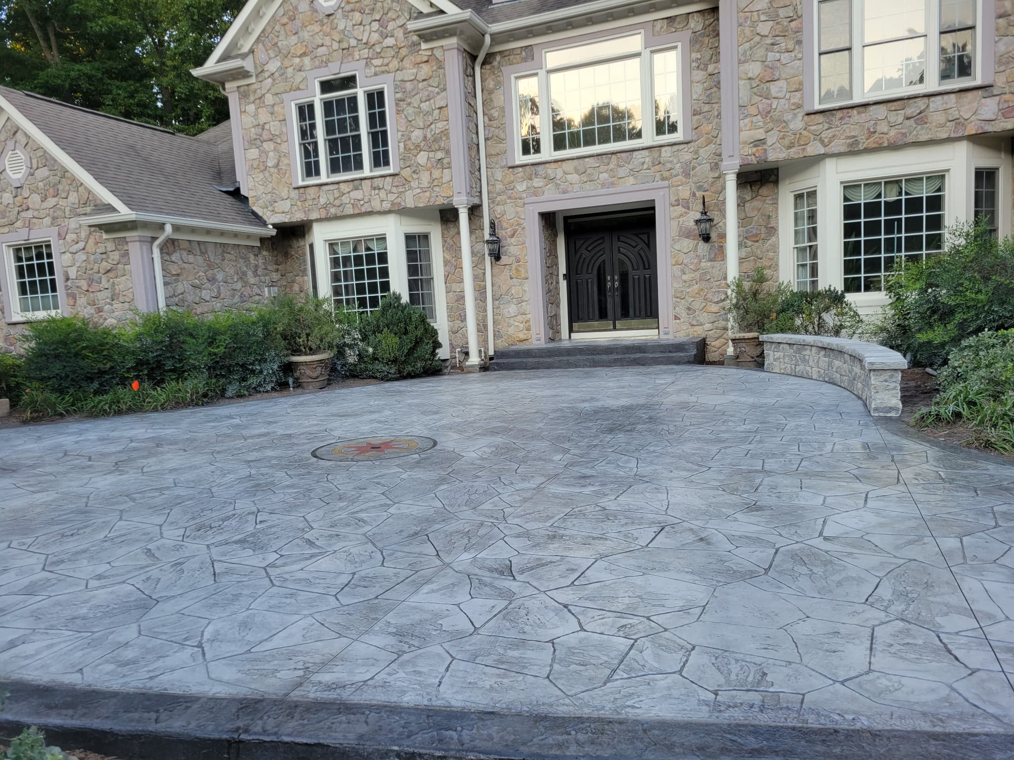 Finished stamped concrete driveway and entry courtyard with a compass medallion in McLean