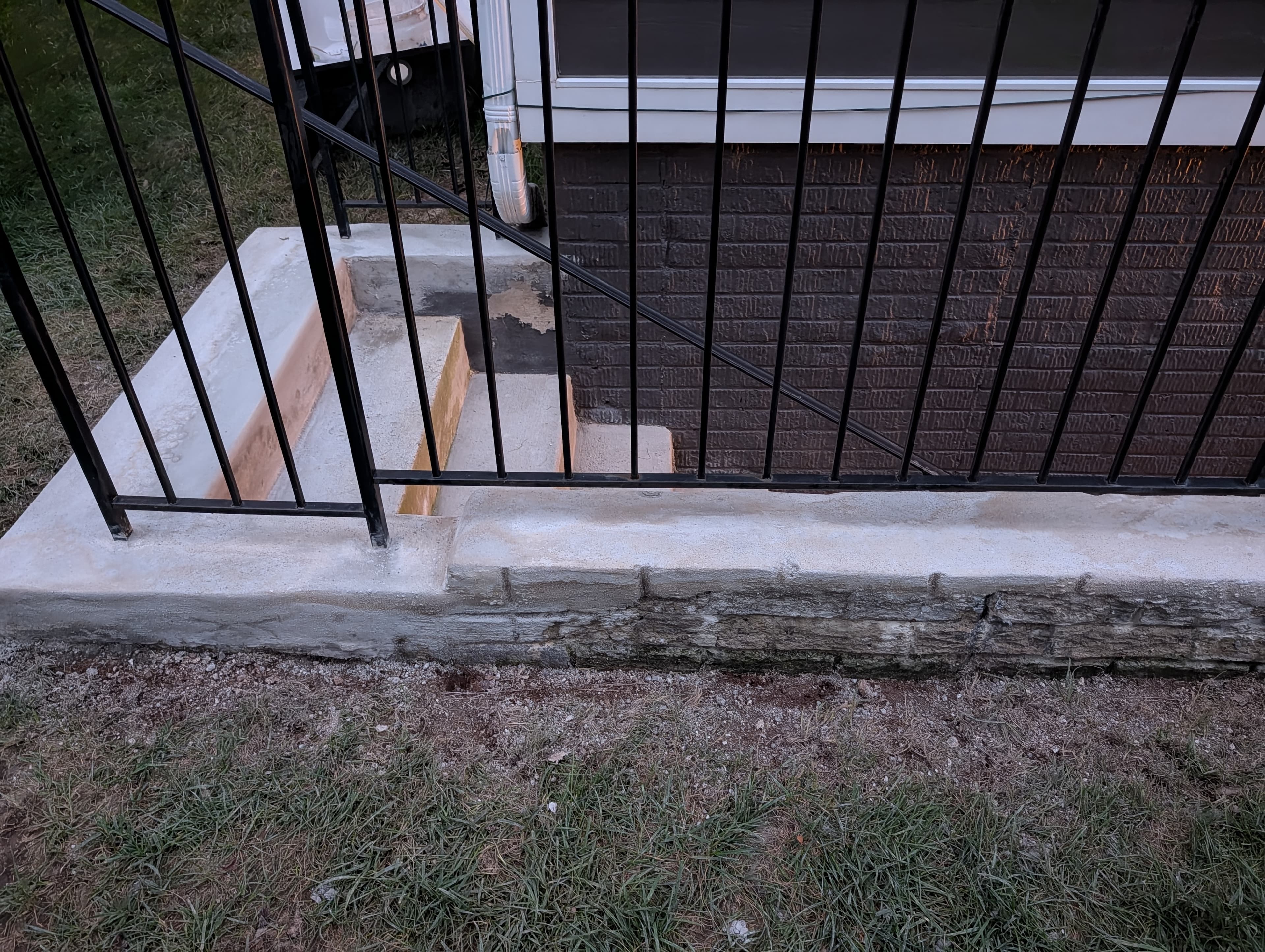Resurfaced walkout basement stairs with a clean, uniform concrete finish, daytime